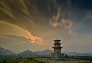 Three storied stupa stands alone under the setting sun