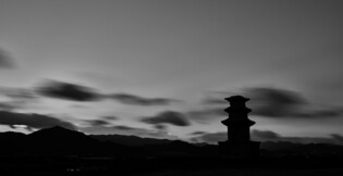 A three storied stupa stands alone under heat wave