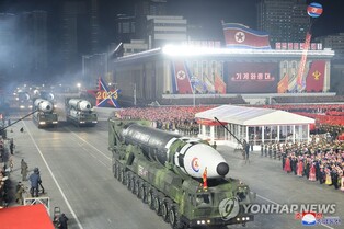 N.K. leader calls for stronger military power in photo session with parade participants