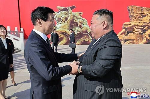 North Korean leader Kim Jong-un (R) and Wang Huning, China's top political adviser, greet each other in Dandong, China, on Oct. 24, 2026, in this photo released by the North's official Korean Central News Agency the following day. (For Use Only in the Republic of Korea. No Redistribution) (Yonhap)