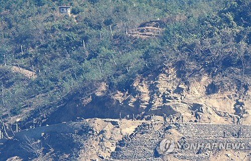  North Korean soldiers work on what appears to be a mission to construct tactical roads and fences near a border area, seen from South Korea's western border island of Ganghwa, in this photo taken Oct. 22, 2026. (Yonhap)