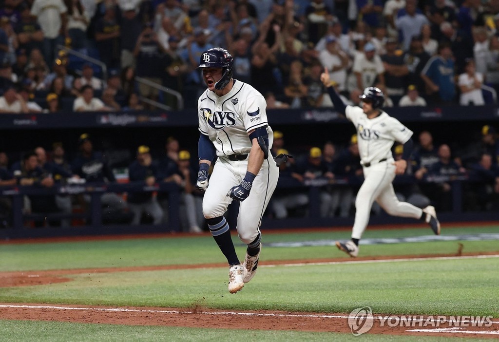 끝내기 안타 친 윌리엄스(앞)과 홈으로 들어오는 주자 [AFP/게티이미지=연합뉴스. 재판매 및 DB 금지]