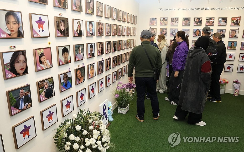 Family members of foreign victims of the 2022 Itaewon crowd crush look at photos of their loved ones at a memorial in central Seoul on Oct. 28, 2026, a day ahead of the fourth anniversary of the tragedy. (Yonhap)
