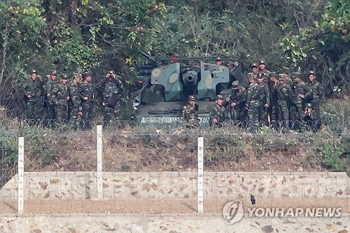  North Korean soldiers gather around what appears to be a self-propelled howitzer deployed in a western coastal border area of Kaepung County, Hwanghae Province, captured from an observation deck in the South Korean city of Gimpo, west of Seoul, on Oct. 26, 2026. (Yonhap)