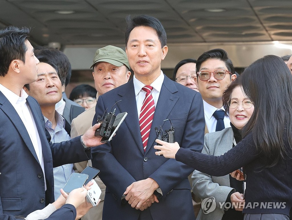 Seoul Mayor Oh Se-hoon (C) speaks to reporters outside the Seoul High Court in southern Seoul after the court acquitted him of charges of violating the Political Funds Act on Oct. 23, 2026. (Yonhap)
