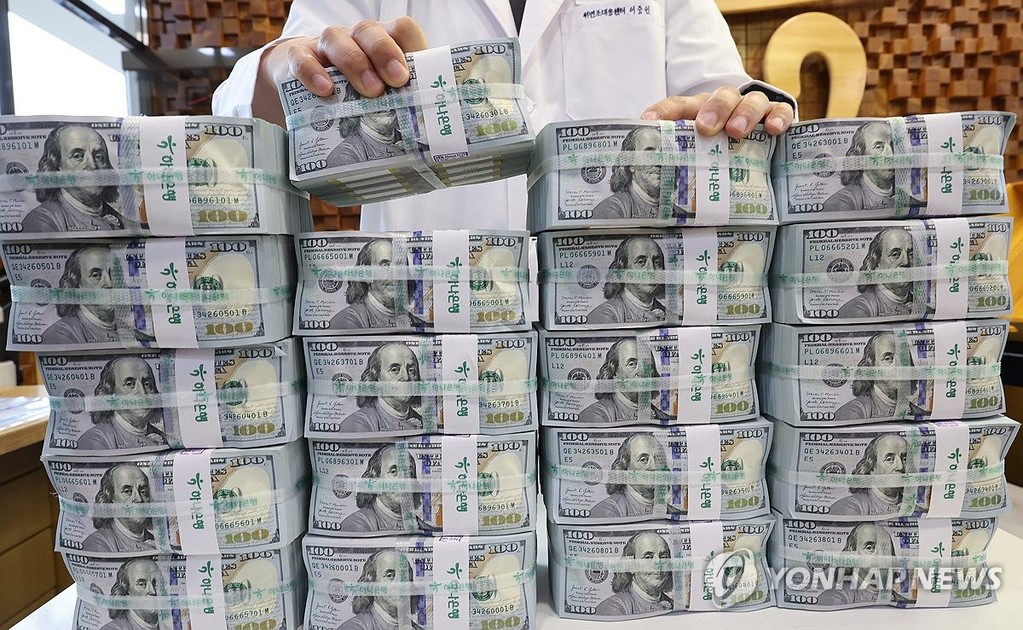  This file photo taken Oct. 6, 2026, shows a clerk checking U.S. dollar notes at a center of Hana Bank in Seoul. (Yonhap)