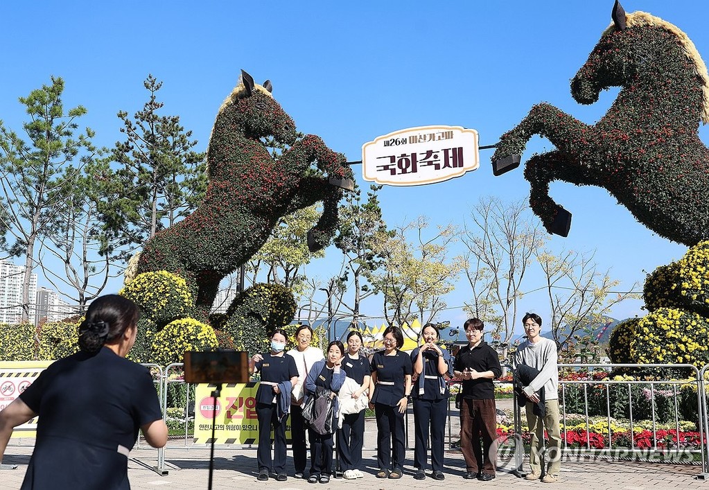 국화축제 추억 (창원=연합뉴스) 김동민 기자 = 제26회 마산가고파국화축제 개막을 하루 앞둔 30일 오후 경남 창원시 마산합포구 3·15해양누리공원 일대에 조성된 축제 현장에서 인근 치과병원 직원들이 기념 촬영을 찍고 있다. 2026.10.30 image@yna.co.kr