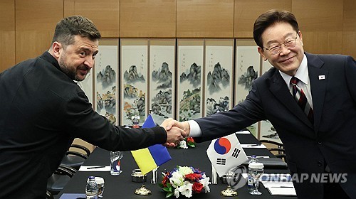  South Korean President Lee Jae Myung (R) and Ukrainian President Volodymyr Zelenskyy shake hands during a summit in Ankara in this July 8, 2026, file photo. (Yonhap)