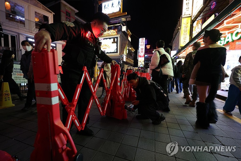 Police officers install a barricade on a street in Seoul's nightlife district of Itaewon for crowd control on Oct. 31, 2026. (Yonhap)